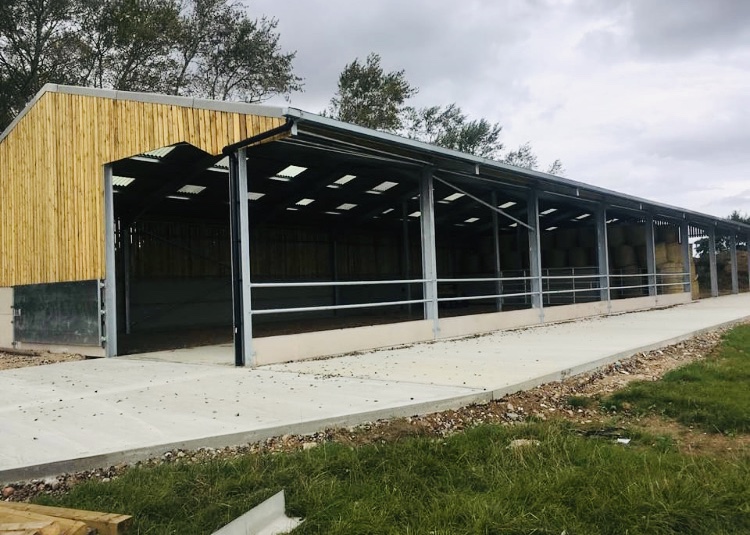 Open-sided steel portal-framed agricultural building on a farm